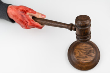 Female judge with bloody hands beats the gavel on a white background.