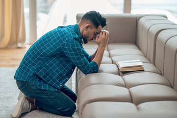 Young muslim praying at home and looking concentrated
