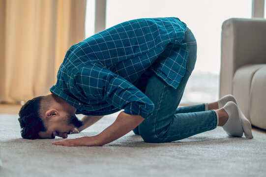 Young Muslim Praying At Home And Bowing