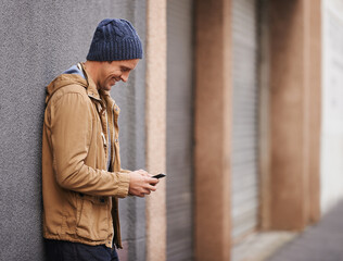 Hooking up with my buddy later on. Cropped shot of a fashionable man using his mobile phone in the...