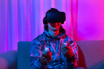 Man wears virtual reality glasses and uses joystick to play games with fun, VR, Future games,...
