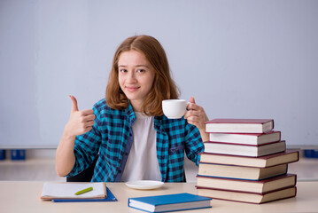 Young female student drinking coffee during break