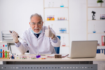 Old male chemist in drug synthesis concept