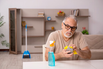 Old man doing housework at home