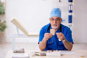 Old male doctor working in the clinic