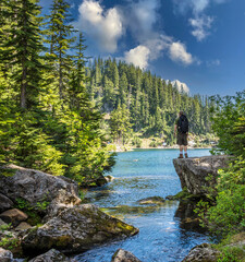 Adventurous male hiker looking at an alpine lake in the Pacific Northwest.