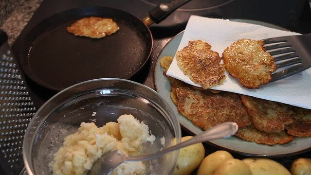 Preparation of homemade vegetable pancakes of grated potato on frying pan. High quality FullHD footage