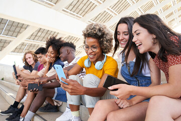 Group of young mixed race people with mobile phones. Excited students using their technological devices. Concept of young enterprising, friendly, selfie, app, hipster, millennial.