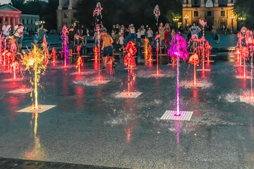 Mykolaiv, Ukraine - July 25, 2020: Pedestrian fountain with brightly illuminated multicolored jets...