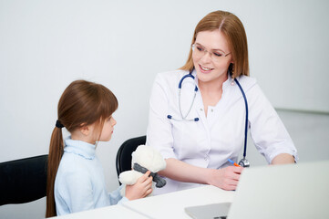 Female caucasian doctor examining little girl in office