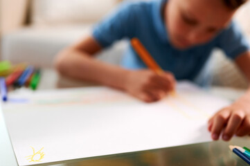 Selective focus. Little schoolboy drawing picture. Back to school. Home schooling and education at home