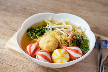 Egg noodles with Japanese colorful fish balls in a white cup