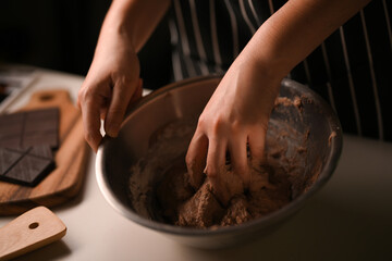 Female mixing the chocolate cookies dough, prepare for baking cookies.
