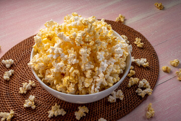 Popcorn in bown on wooden background. Popcorn in bowl on wooden table.