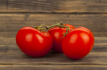 Red tomatoes on a wooden background.