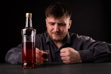 A man with a beard drinks alcohol.