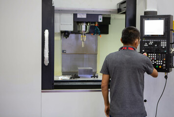 Mechanical technician operating CNC milling machine in workshop. Industrial manufacturing.  © Itsanan