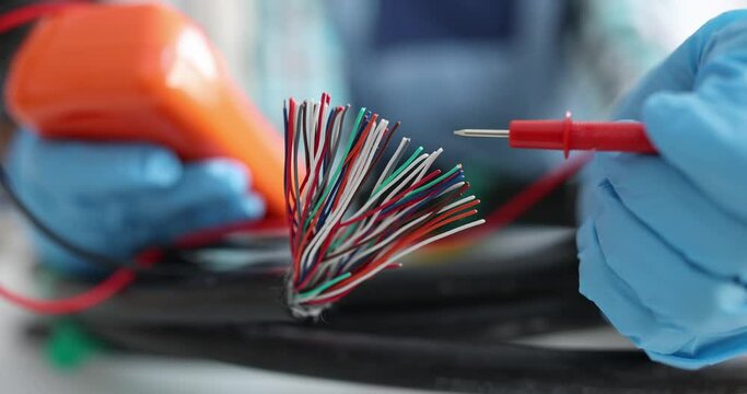 Digital multimeter testing electrical wires by an electrician