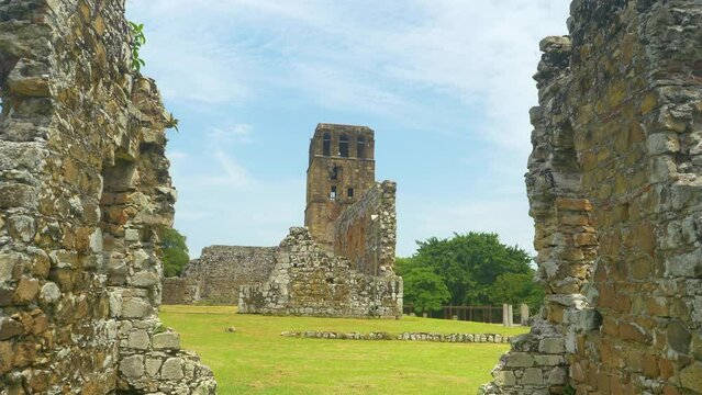 CLOSE UP: Ancient cathedral towers above the decaying buildings of Old Panama. Scenic shot of the decaying ruins of Panama Viejo surrounded by lush tropical vegetation. UNESCO heritage site in Panama.