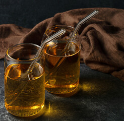 Two glasses of apple juice cocktail on a dark background