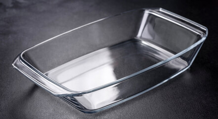 A rectangular glass empty dish for baking on a dark concrete background