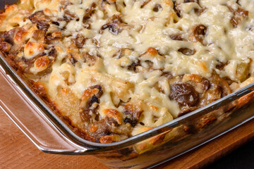 A delicious nutritious dish with meat, mushrooms, vegetables and potatoes, baked in a creamy sauce in an oven