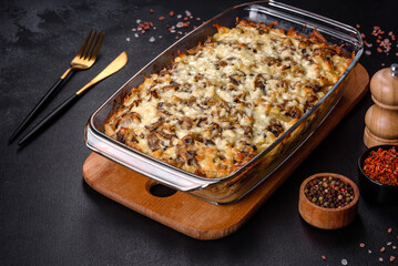 A delicious nutritious dish with meat, mushrooms, vegetables and potatoes, baked in a creamy sauce in an oven