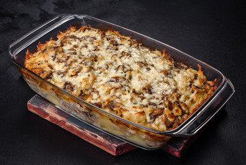 A delicious nutritious dish with meat, mushrooms, vegetables and potatoes, baked in a creamy sauce in an oven