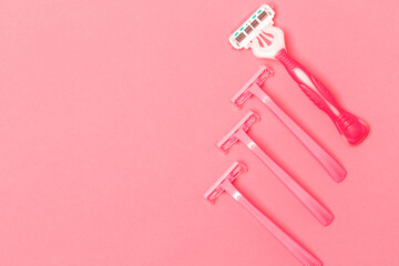 Hygiene Ideas. Variety of Four Female Pink Disposable Razors Shavers Placed Together Over Trendy Pink Coral Background.