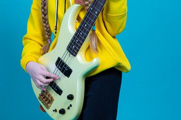 Closeup of Hands of Caucasian Female Guitar Player With Yellow Bass Guitar Posing In Fashionable...