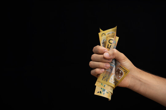hand of a man squeezing australian dollars