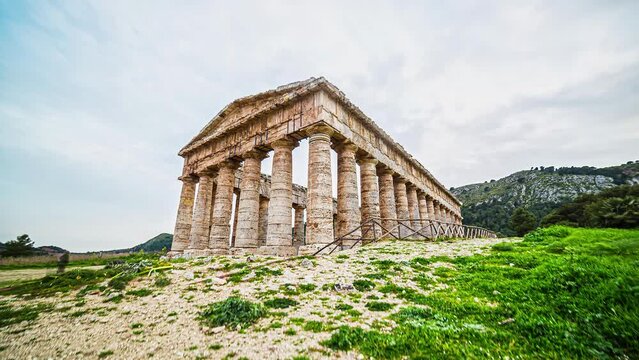 Low angle shot of the Greek Temple of Segesta, Sicily in Italy, Europe on a cloudy day with cloud movment in timelapse.