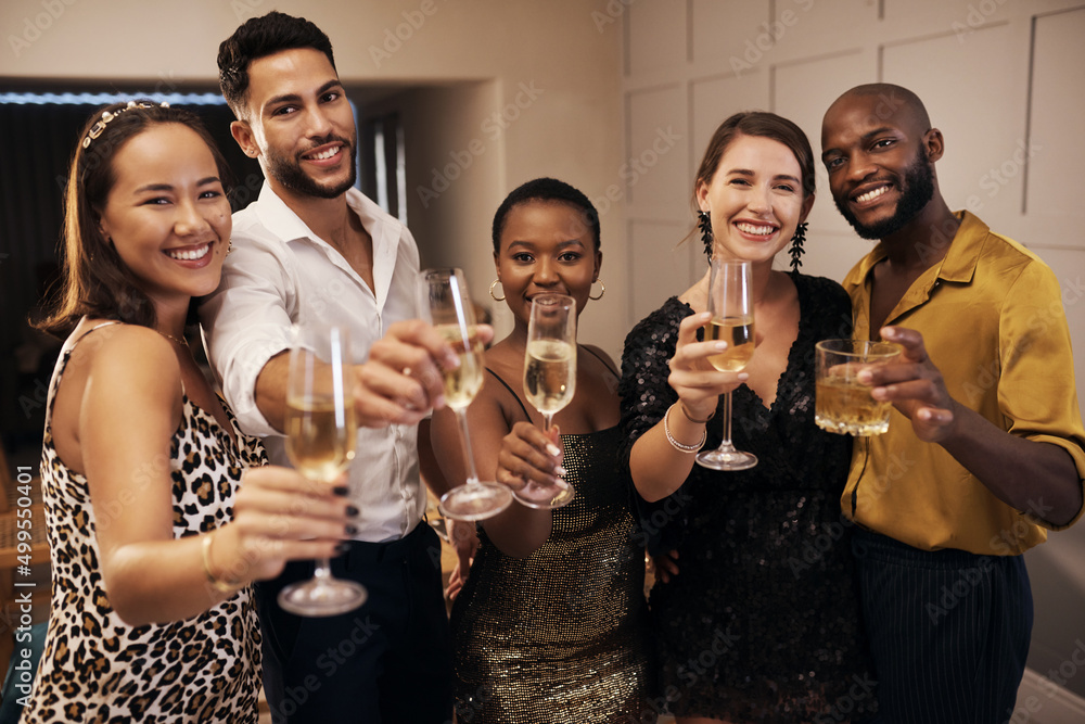 Wall mural come celebrate with us. shot of a diverse group of friends standing together and holding glasses of 