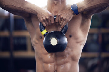 He hustled, he got that muscle. Shot of an unrecognisable man working out with a kettle bell at the...