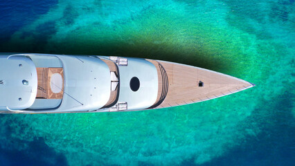 Aerial drone top down photo of luxury exotic yacht nose with wooden deck anchored in paradise...