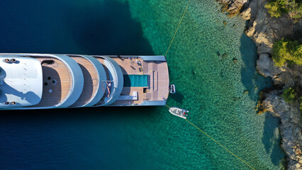 Aerial drone top down photo of luxury exotic yacht nose with wooden deck anchored in paradise turquoise bay - obrazy, fototapety, plakaty