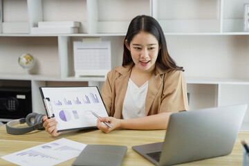 Online lifestyle concept A female home worker explaining her diagrams on the paper to her boss on the online meeting.