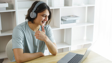 Distance education concept, Teen boy wear headphone and make gestures while listen lecture online