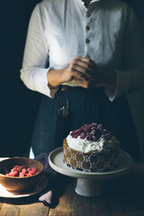 Woman with birthday cake on a dark background