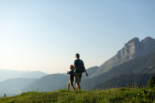 Father and son hiking with a  view in the Austrian Alps. Active family vacation concept
