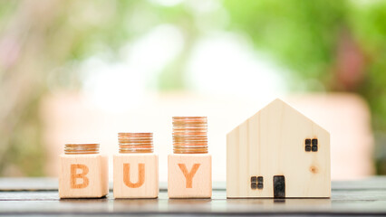 Wood block word BUY and house model. Real estate and property concept.