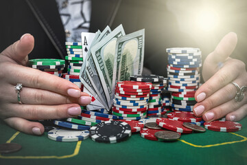 Naklejka premium female player counts chips on money and raises bet by playing poker at casino