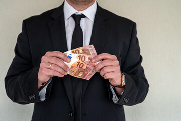 Business man wearing suit giving euro banknotes to subordinate office.