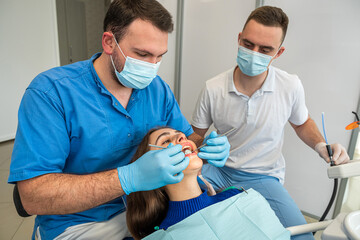 professional treating female patient teeth at dental clinic