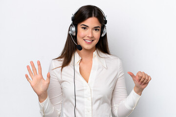Telemarketer caucasian woman working with a headset isolated on white background counting six with fingers