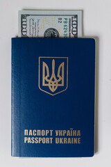 Hundred US dollar bill inside Ukrainian passport. Bribe during the war