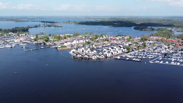 Aerial airplane view of Loosdrecht which is known for its lakes flight over the Loosdrechtse Plassen towards the Oud-Loosdrechtsedijk which thousands of tourists visit every year 4k high resolution