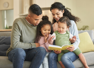 Love as clear and crystal. Shot of a young family bonding while reading a book together at home.