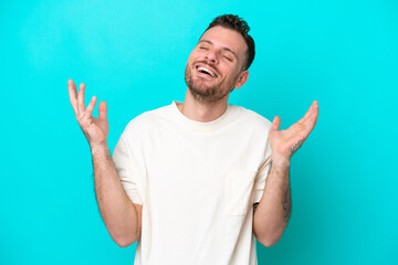 Naklejka premium Young Brazilian man isolated on blue background smiling a lot