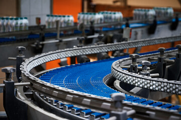 Empty plate conveyor belt and bottles at production line - 499559243